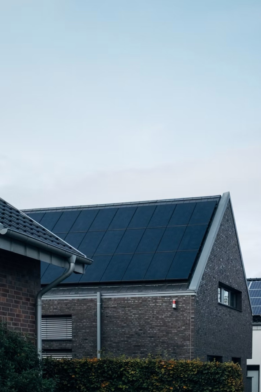 A modern home with rooftop solar panels at dusk